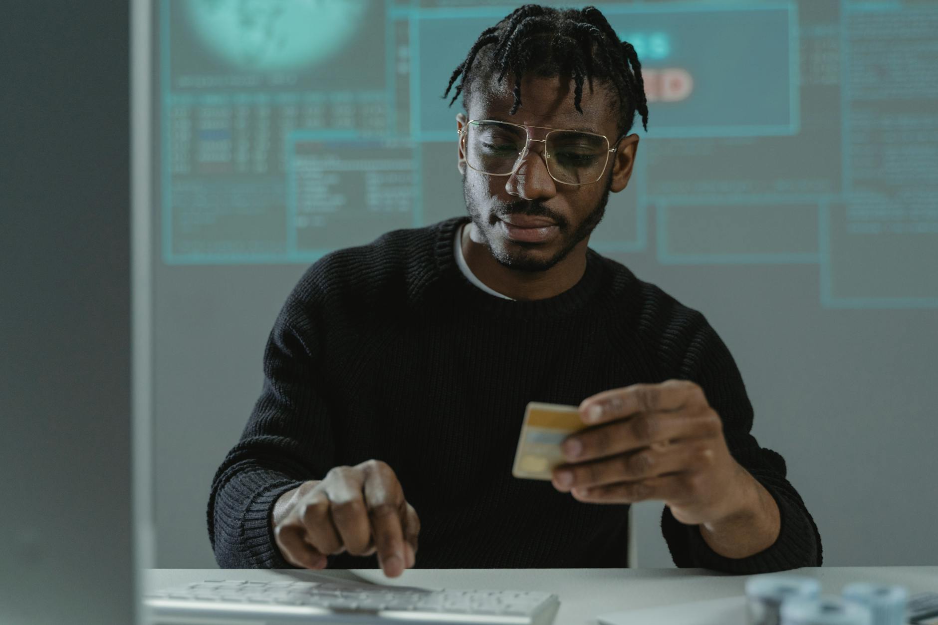 A person at a laptop with digital security overlay representing voice cloning threats to banking