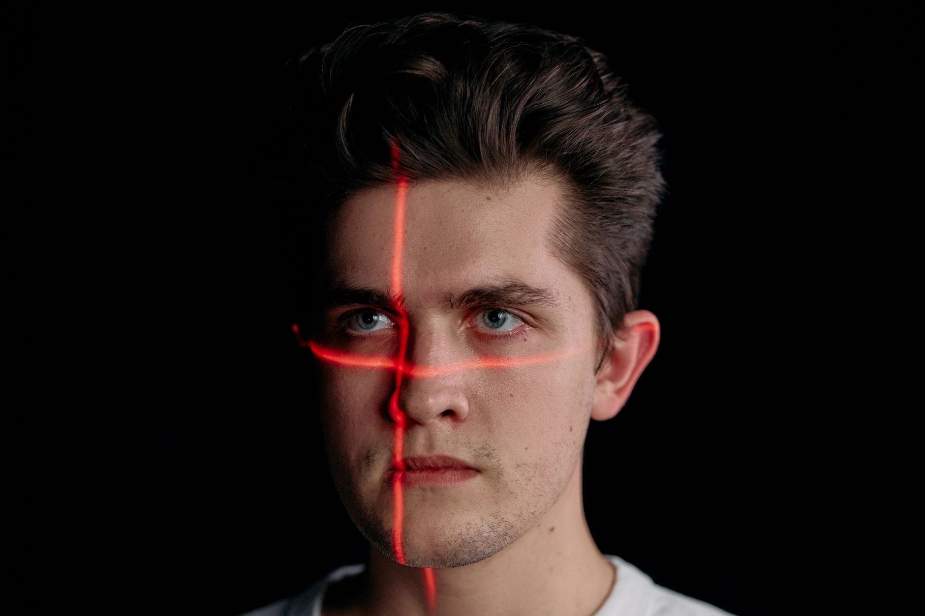 Digital facial recognition scan overlaying a person's face, representing biometric identity verification at onboarding