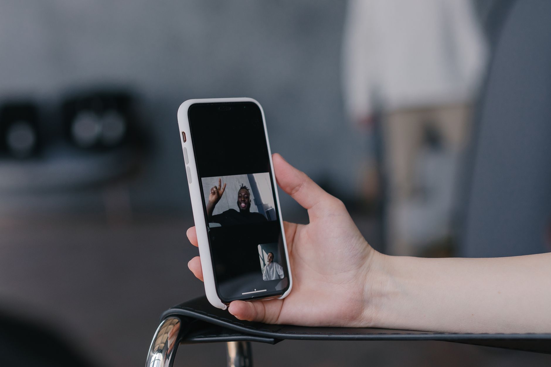 Close-up of a hand holding a smartphone during a live video call, illustrating the video-call trust check dating apps rely on