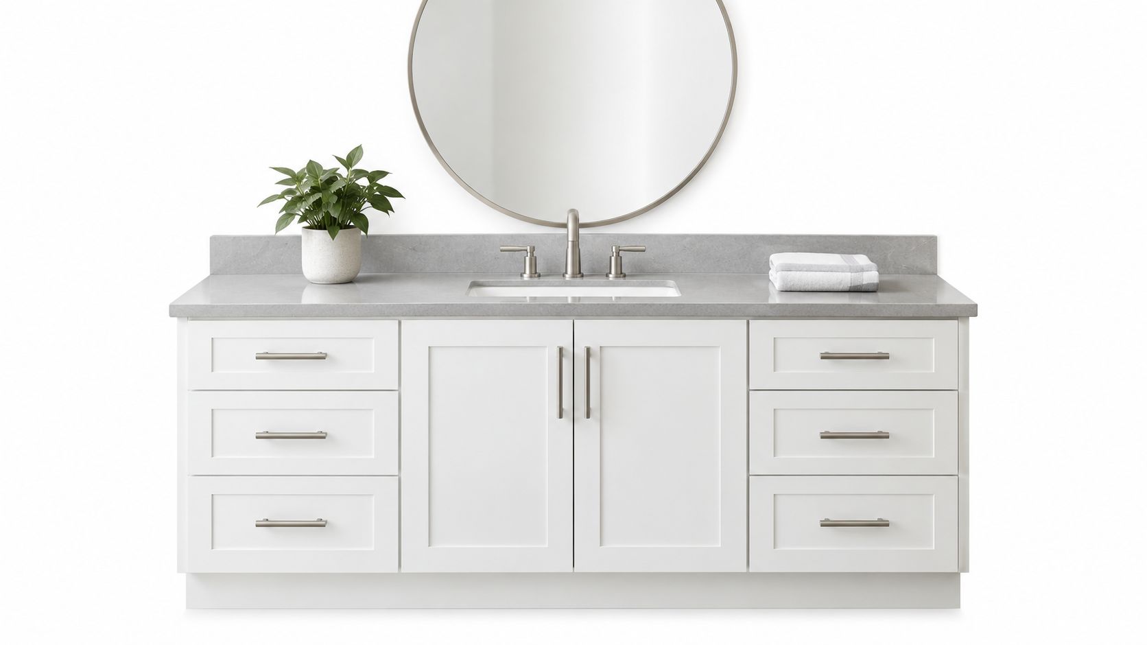 A modern white bathroom vanity with a grey stone countertop, round mirror, and a small potted plant.