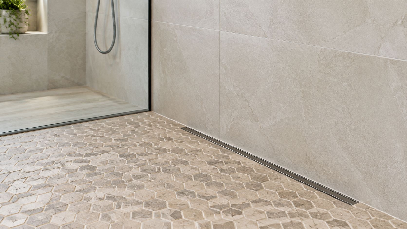A modern walk-in shower featuring textured stone mosaic floor tiles and elegant large wall tiles.