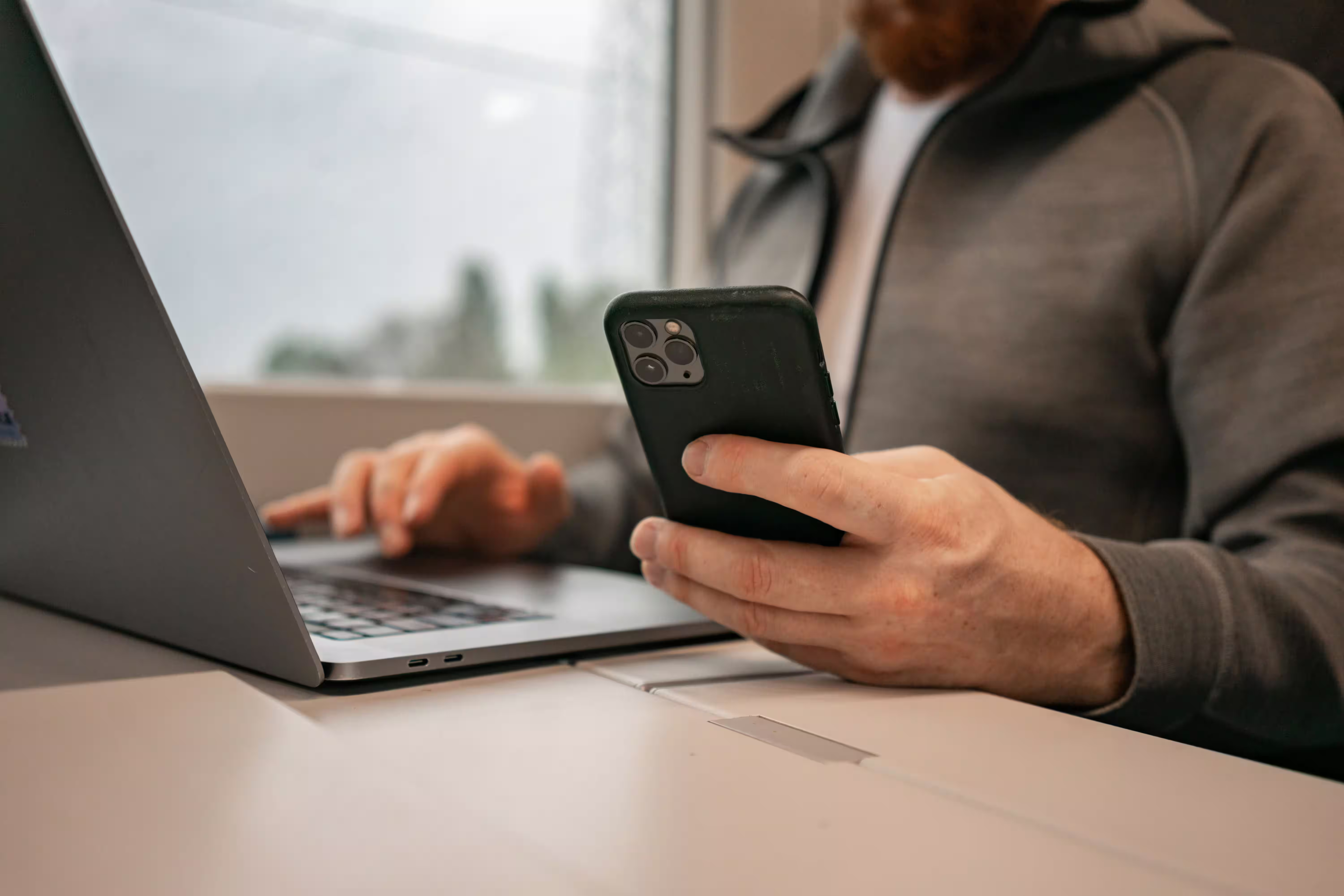 A picture of a man setting an automation on his compter and phone