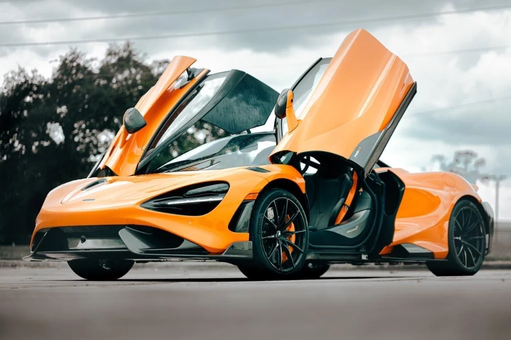 Bright orange McLaren 720S with butterfly doors open after an exotic car detail at Allure Auto Spa in Casselberry, Florida.