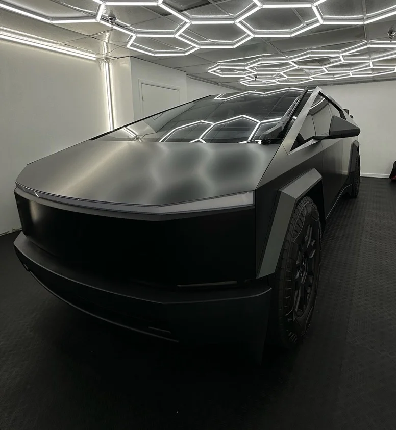 Tesla Cybertruck wrapped in matte black film under shop lighting at Allure Auto Spa in Casselberry, Florida
