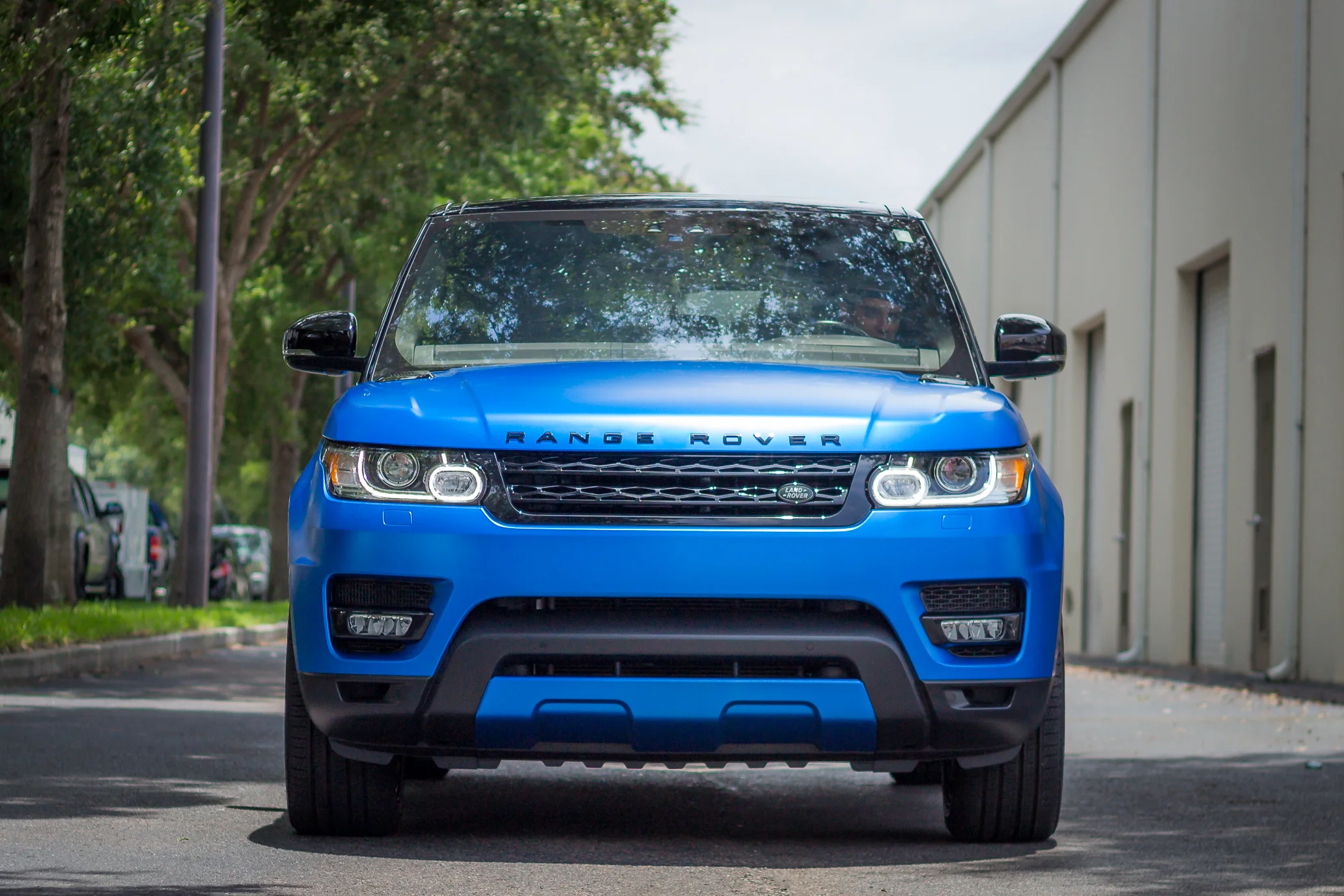 Front view of a satin blue wrapped Range Rover parked outside Allure Auto Spa in Casselberry, Florida