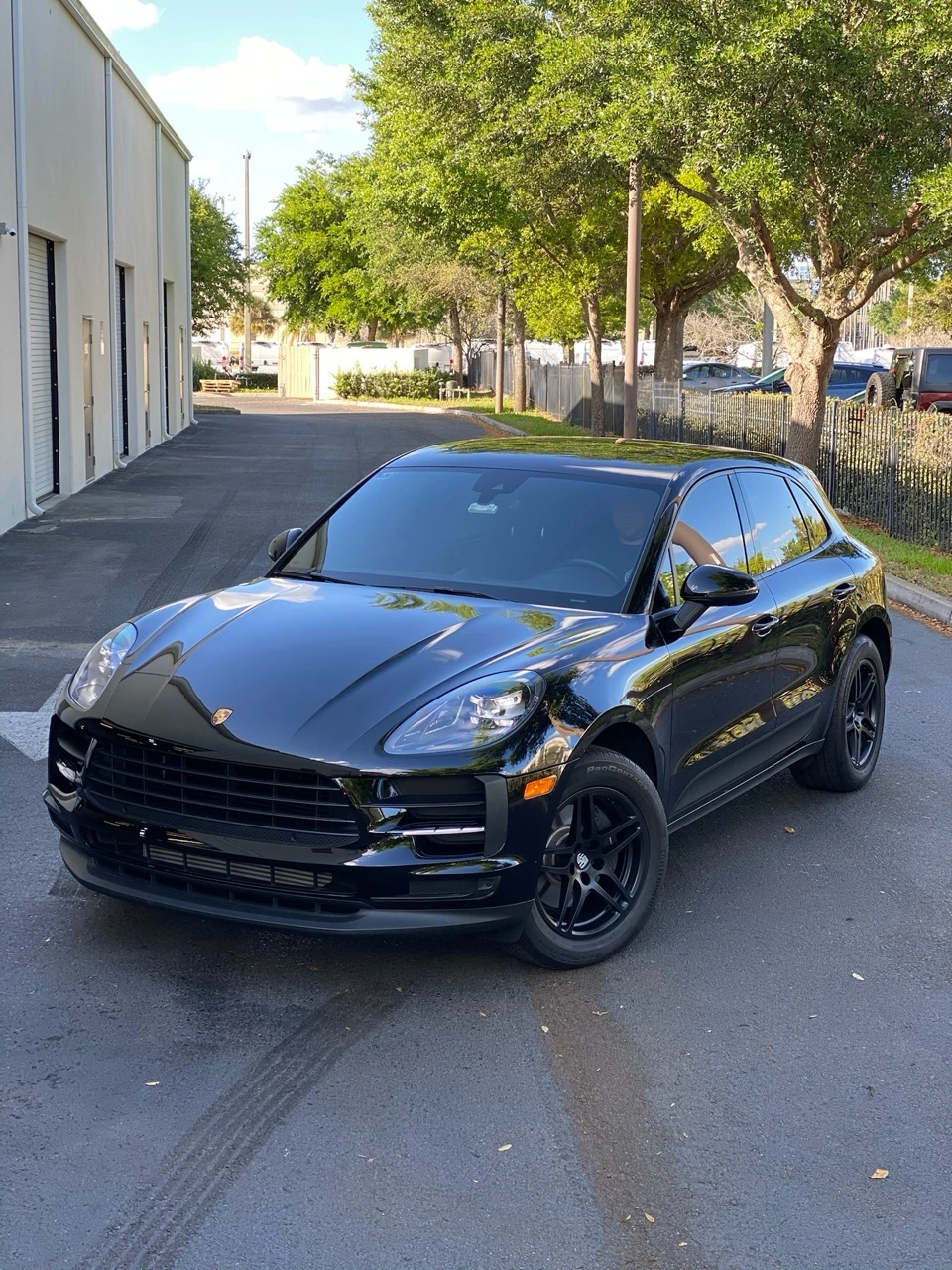 Glossy black Porsche Macan reflecting the shine of a fresh ceramic coating at Allure Auto Spa in Casselberry, Florida