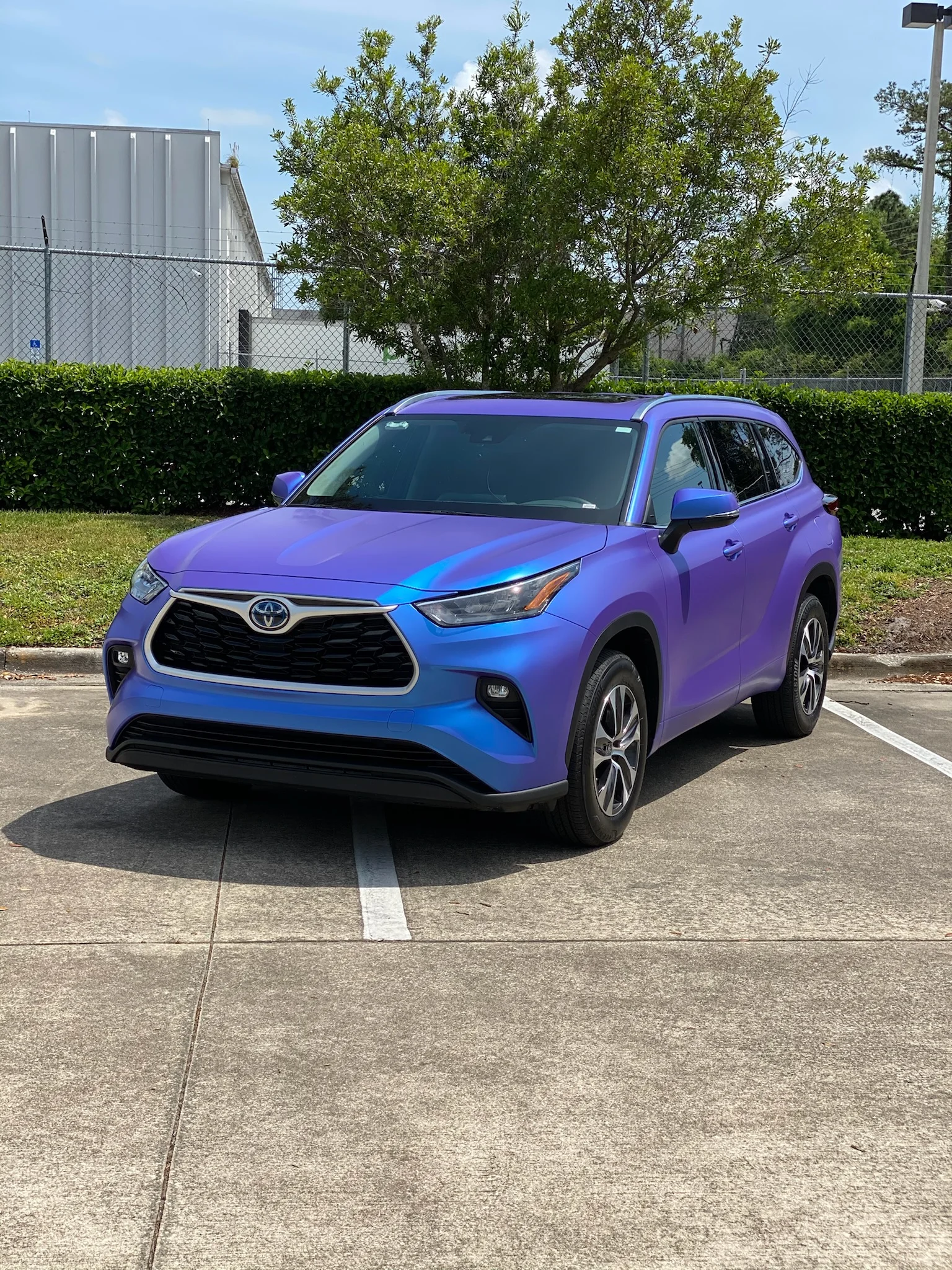 A Toyota Highlander SUV featuring a striking color-shift car wrap from purple to blue, installed by Allure Auto Spa