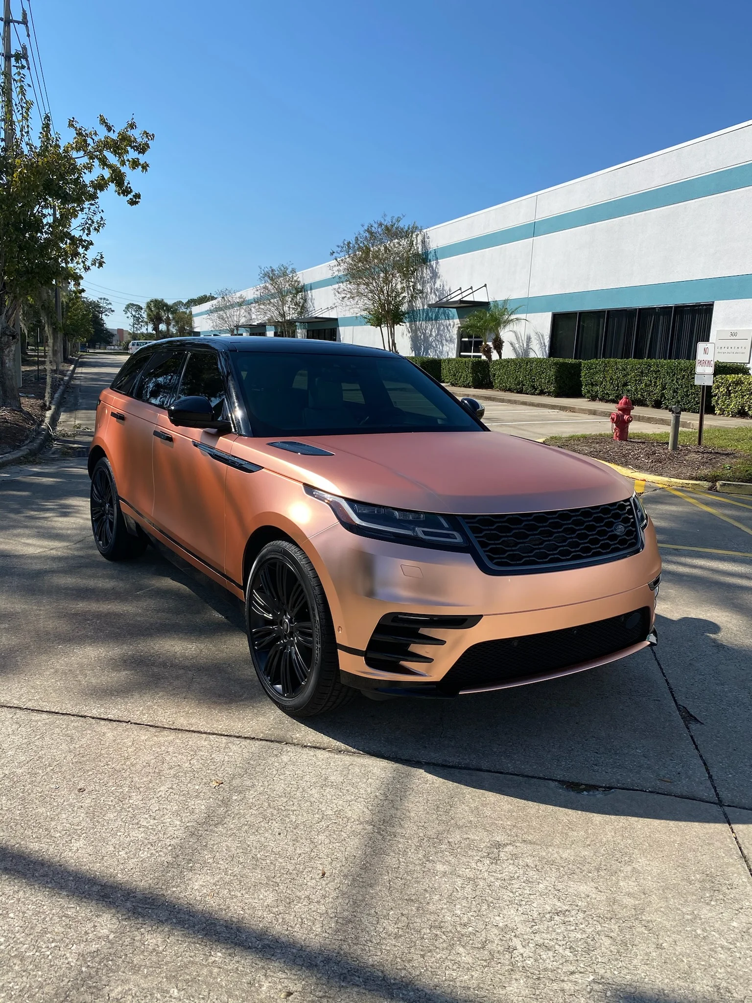 Range Rover Velar with a rose gold satin wrap and deep window tint parked outside Allure Auto Spa in Casselberry, Florida