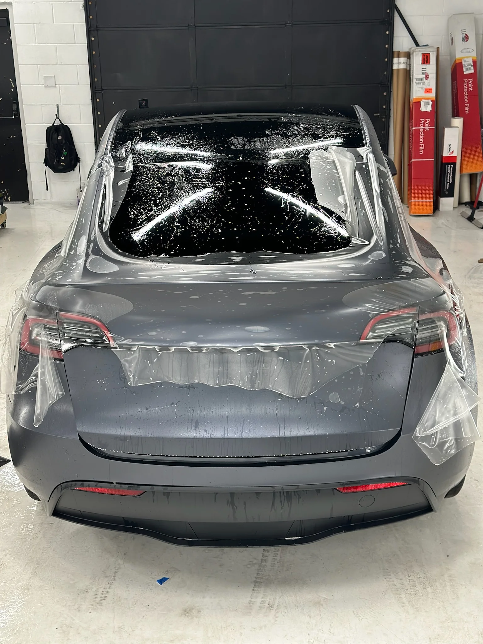 Paint protection film installation in progress on the rear and roof of a Tesla Model Y at Allure Auto Spa in Casselberry, Florida