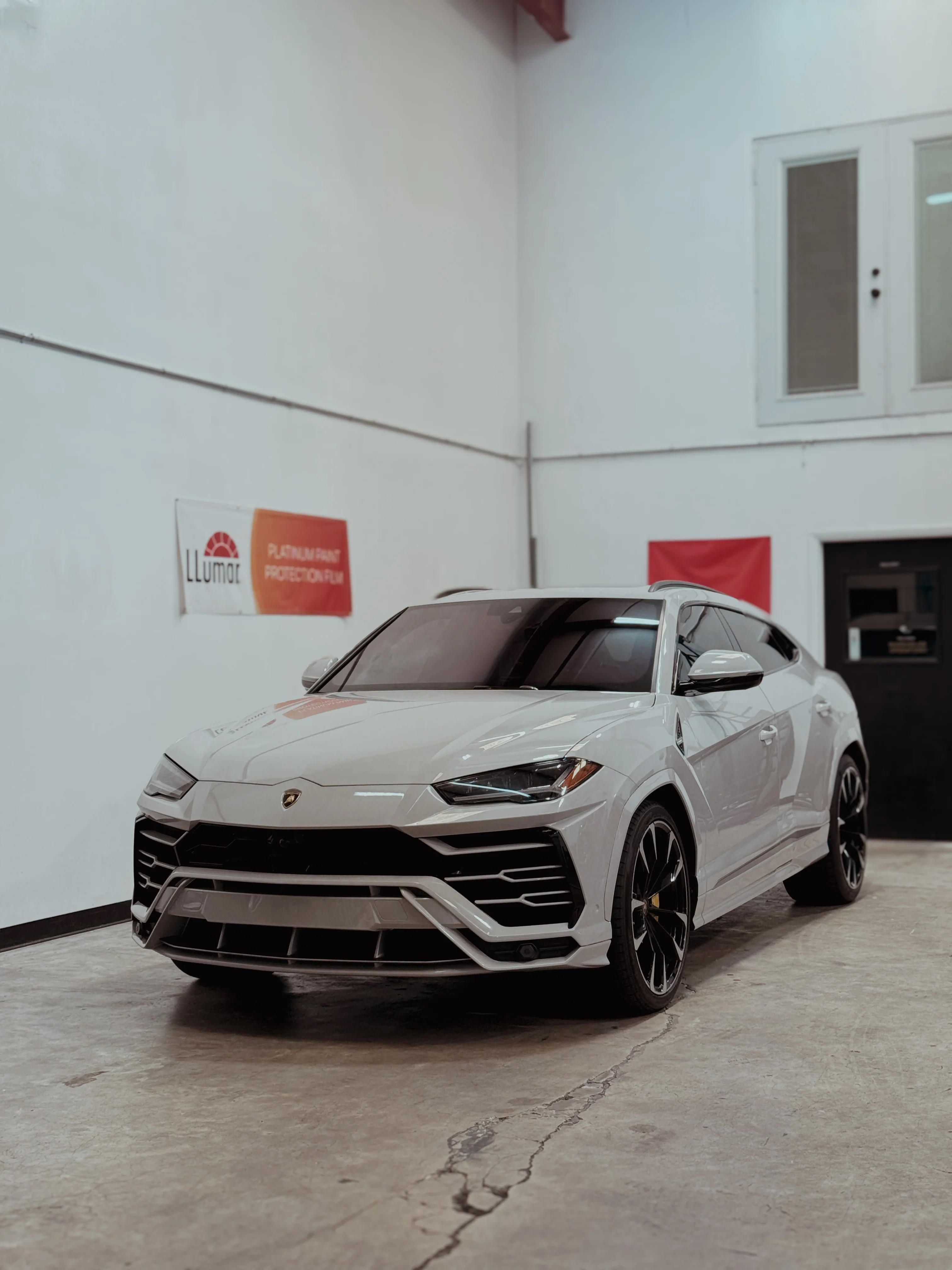 Luxurious Lamborghini Urus SUV with a pristine satin white paint protection film and wrap, installed by Allure Auto Spa