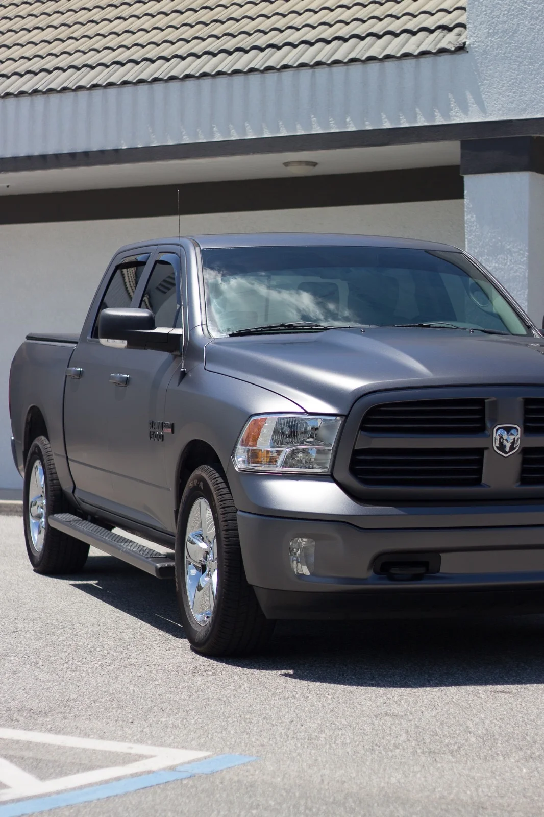 Full exterior view of a Ram 1500 truck with a sleek matte grey car wrap, a professional finish by Allure Auto Spa