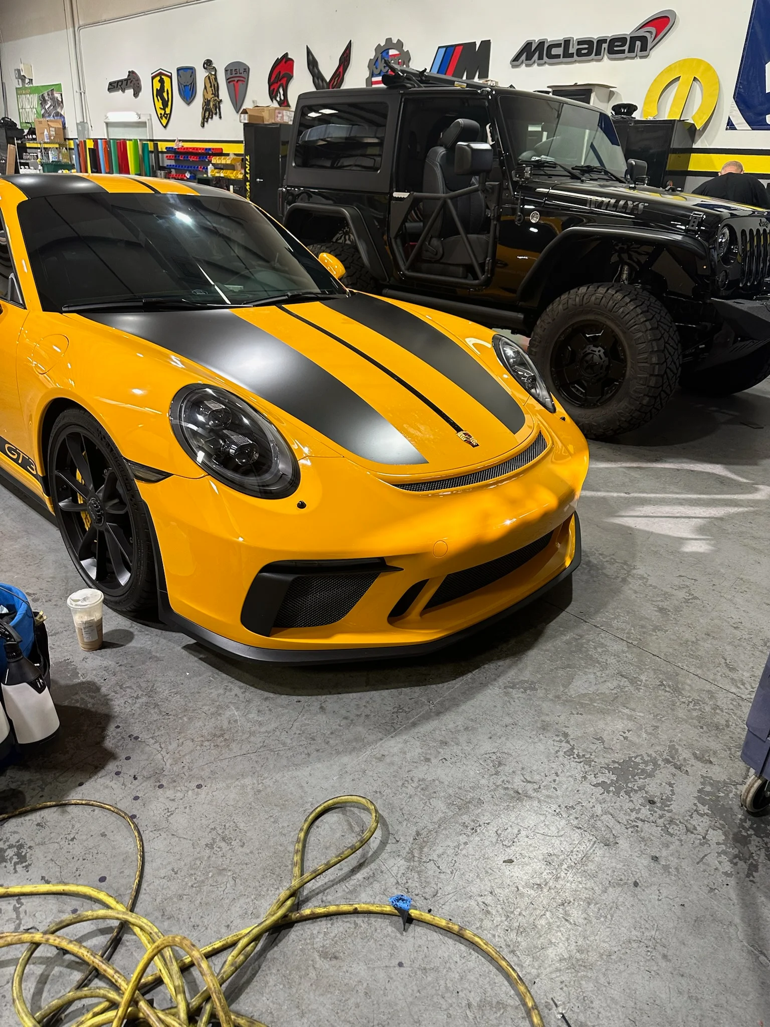 Stunning yellow Porsche 911 GT3 with custom black racing stripes, showcasing high-performance car wraps at Allure Auto Spa