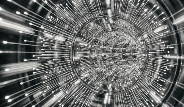  A modern GPU with a dual-fan design, featuring a sleek silver and black color scheme, lies on a wooden surface.