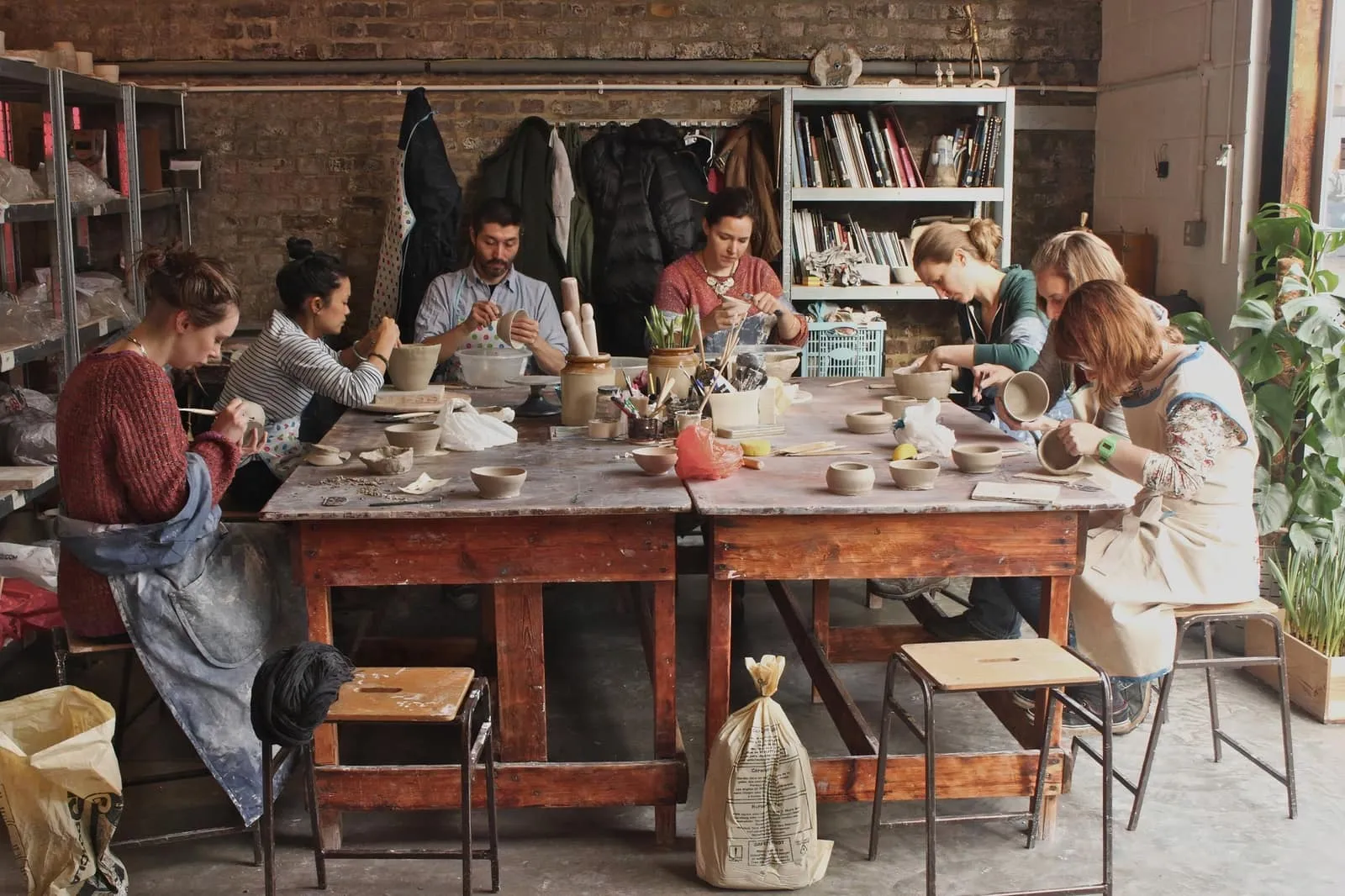 Pottery studio with natural light and students at wheels