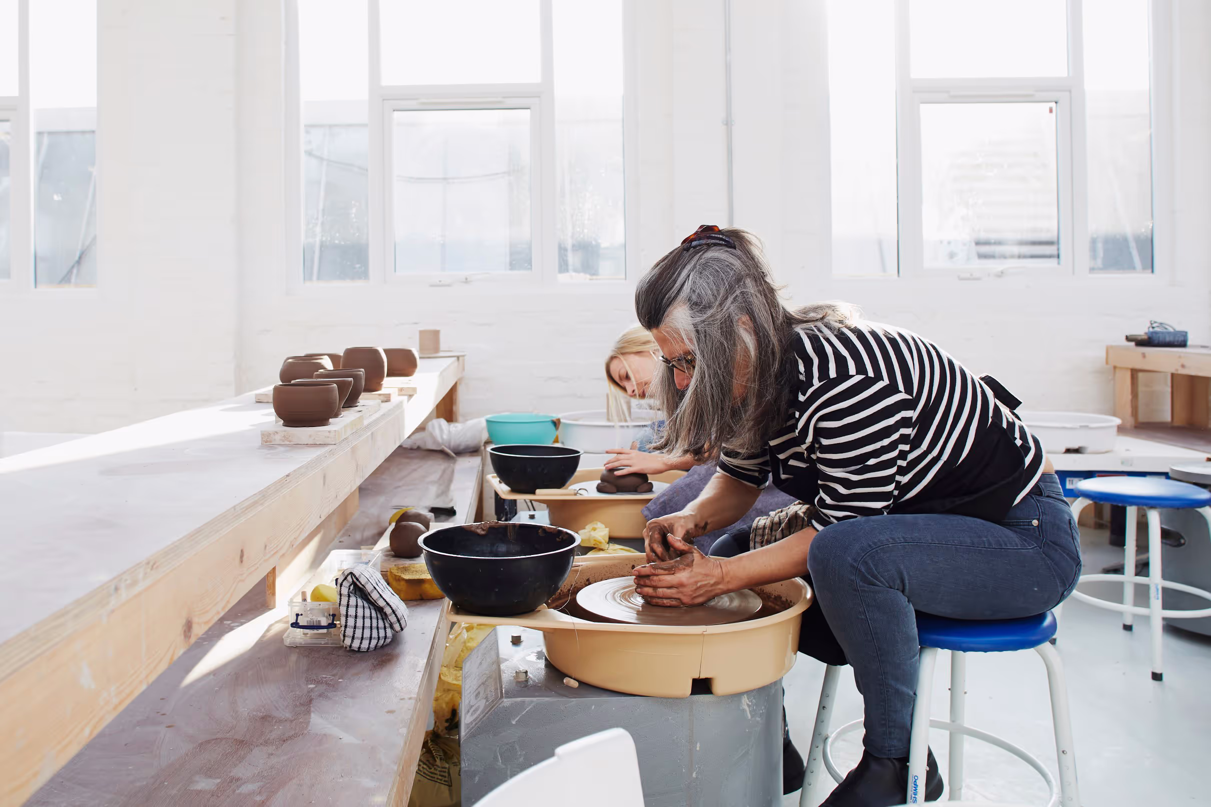 Group working on pottery in a well-lit studio