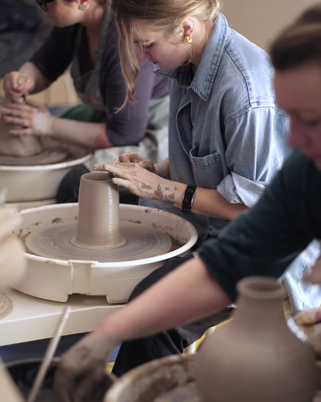 Group working on pottery in a well-lit studio