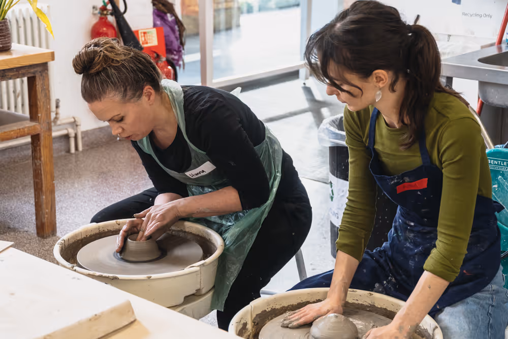 Person shaping clay on a pottery wheel