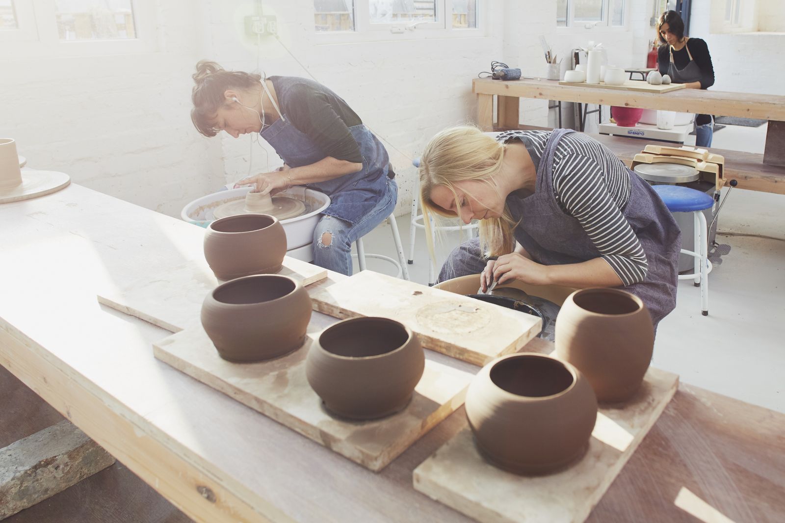 Two members working on a batch of pots at Turning Earth Leyton