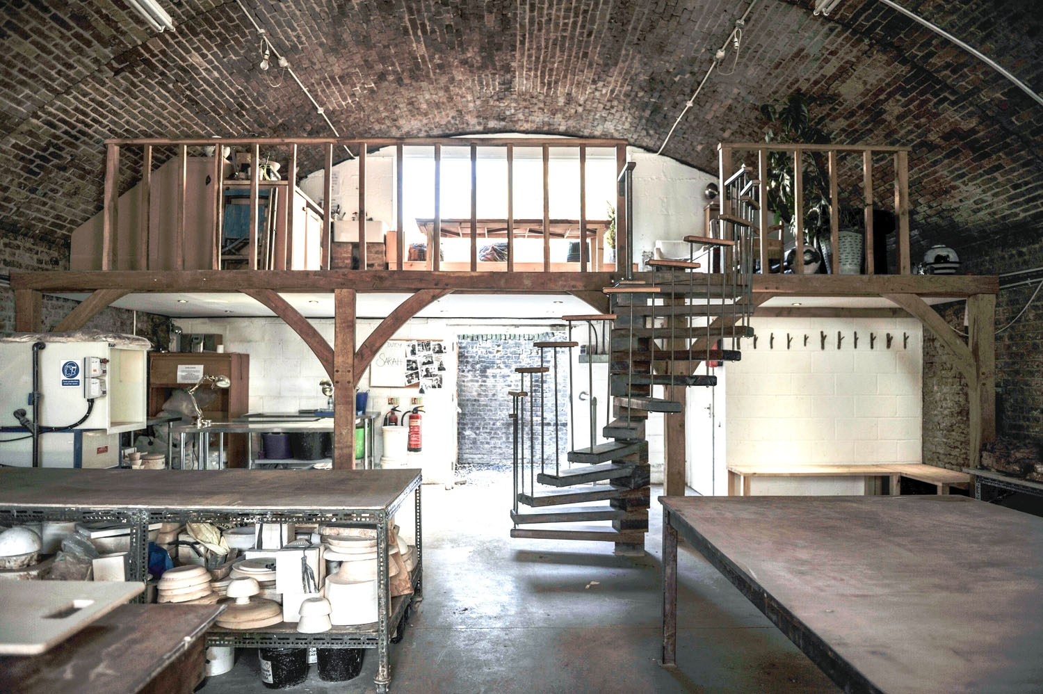 The Hoxton arch with its timber mezzanine and spiral stair, workbenches and shelves of studio equipment