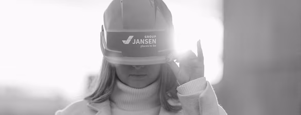 Person wearing a hard hat with Group Jansen logo, adjusting the helmet brim with one hand in black and white.