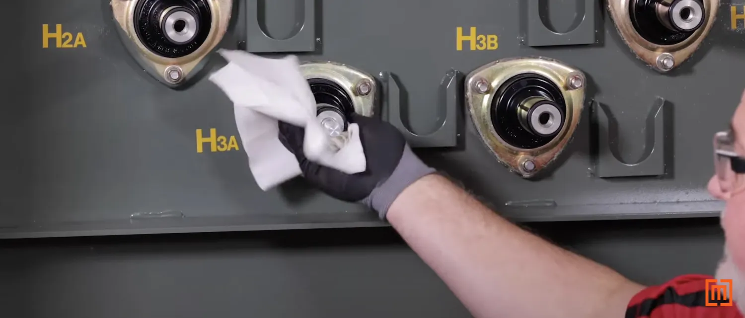 Technician applying silicone to padmount bushing
