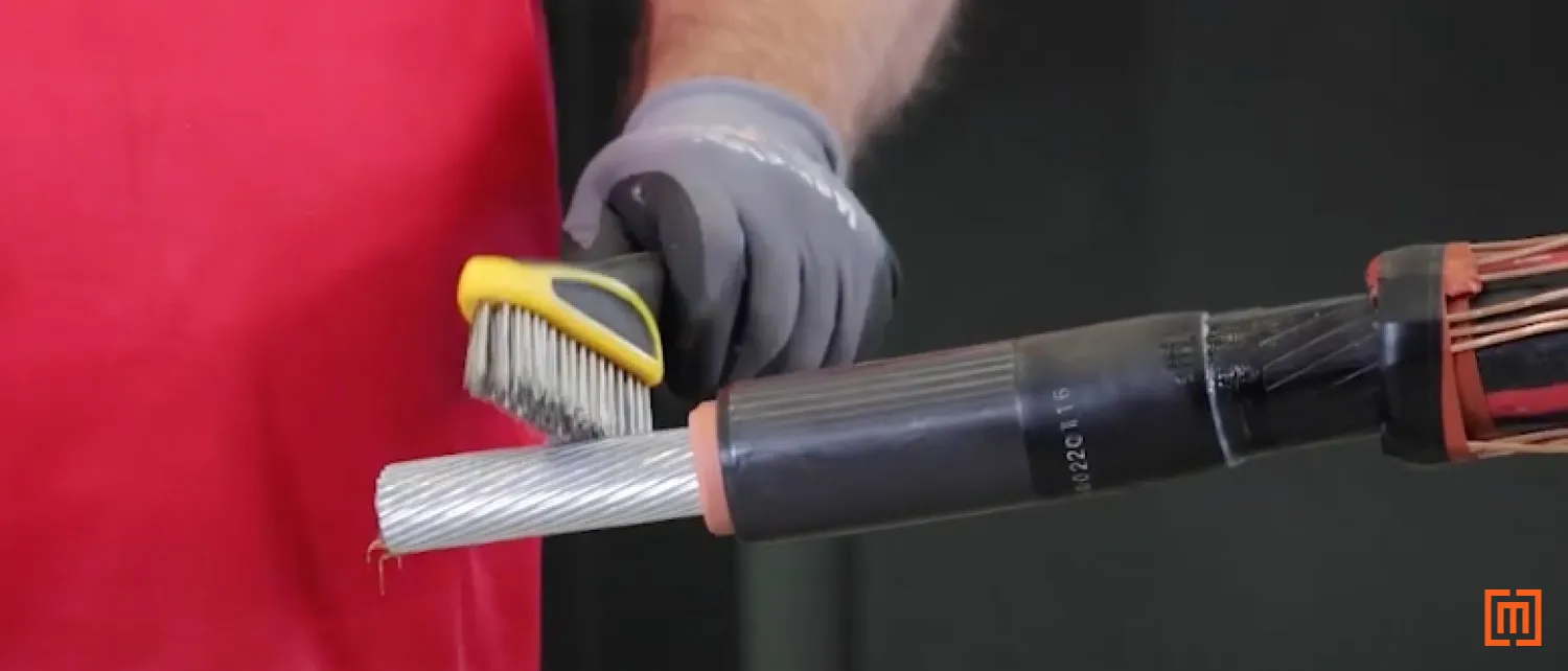 Wire brush touching exposed cable