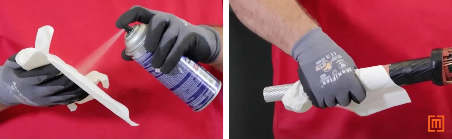 Technician sprays cable cleaner into a paper towel and wipes cable