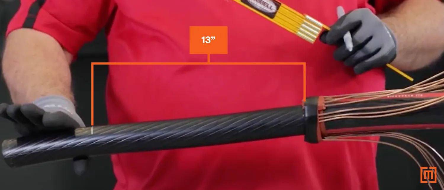 Technician measures thirteen inches on the cable from the tape