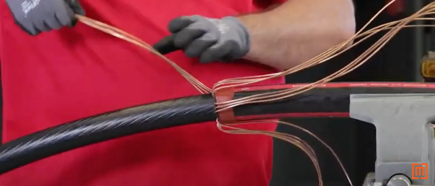 Technician folds concentric neutral cables back to the mastic tape