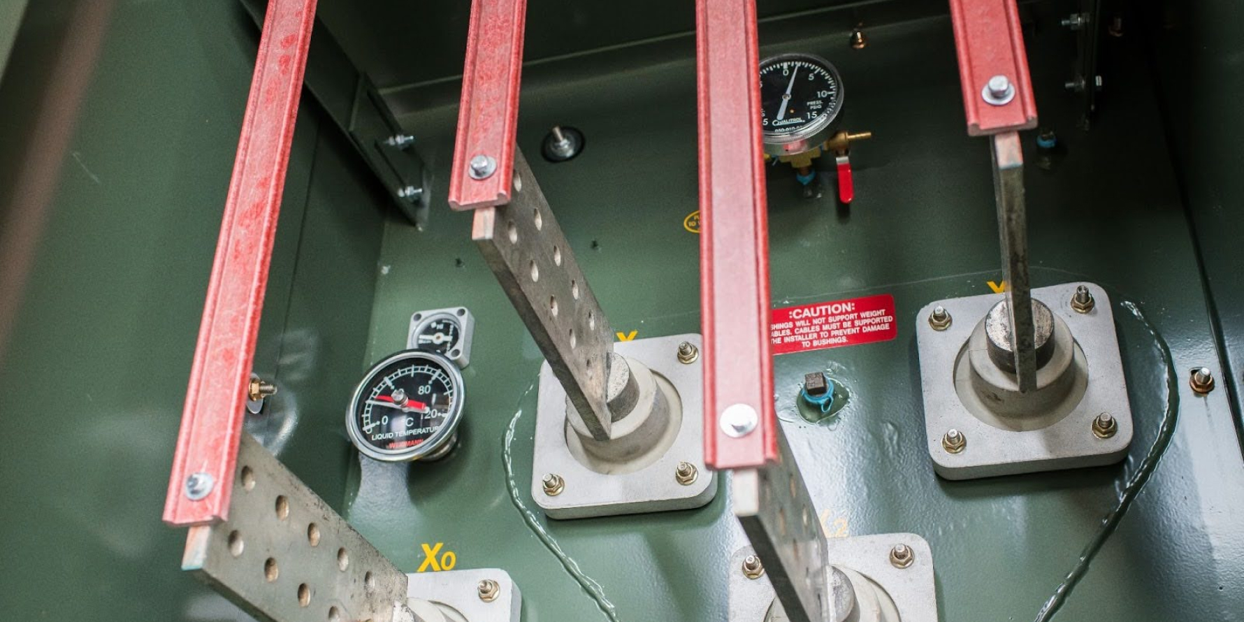 Low voltage bushing supports attached to transformer spades