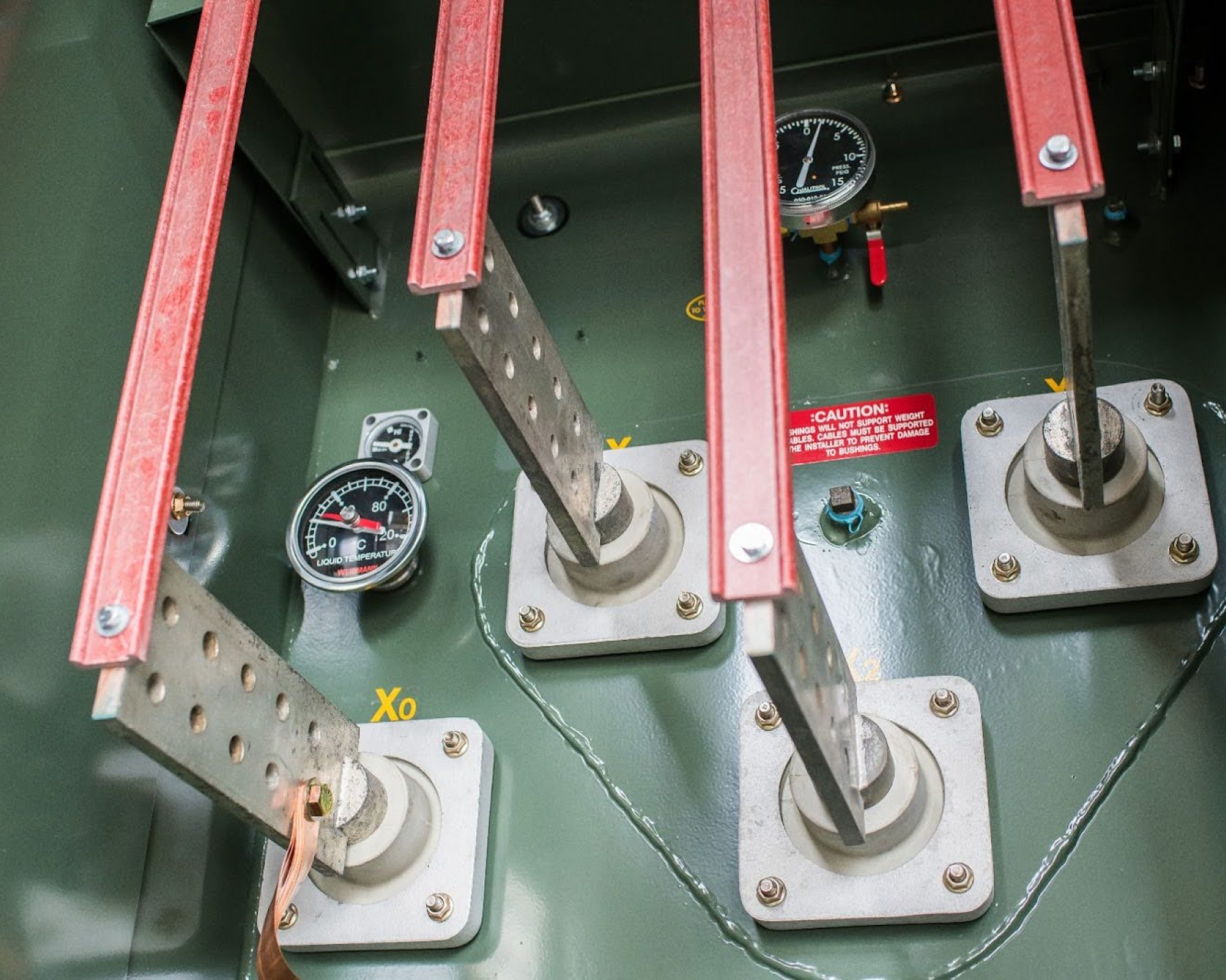 Low voltage bushing supports attached to transformer spades