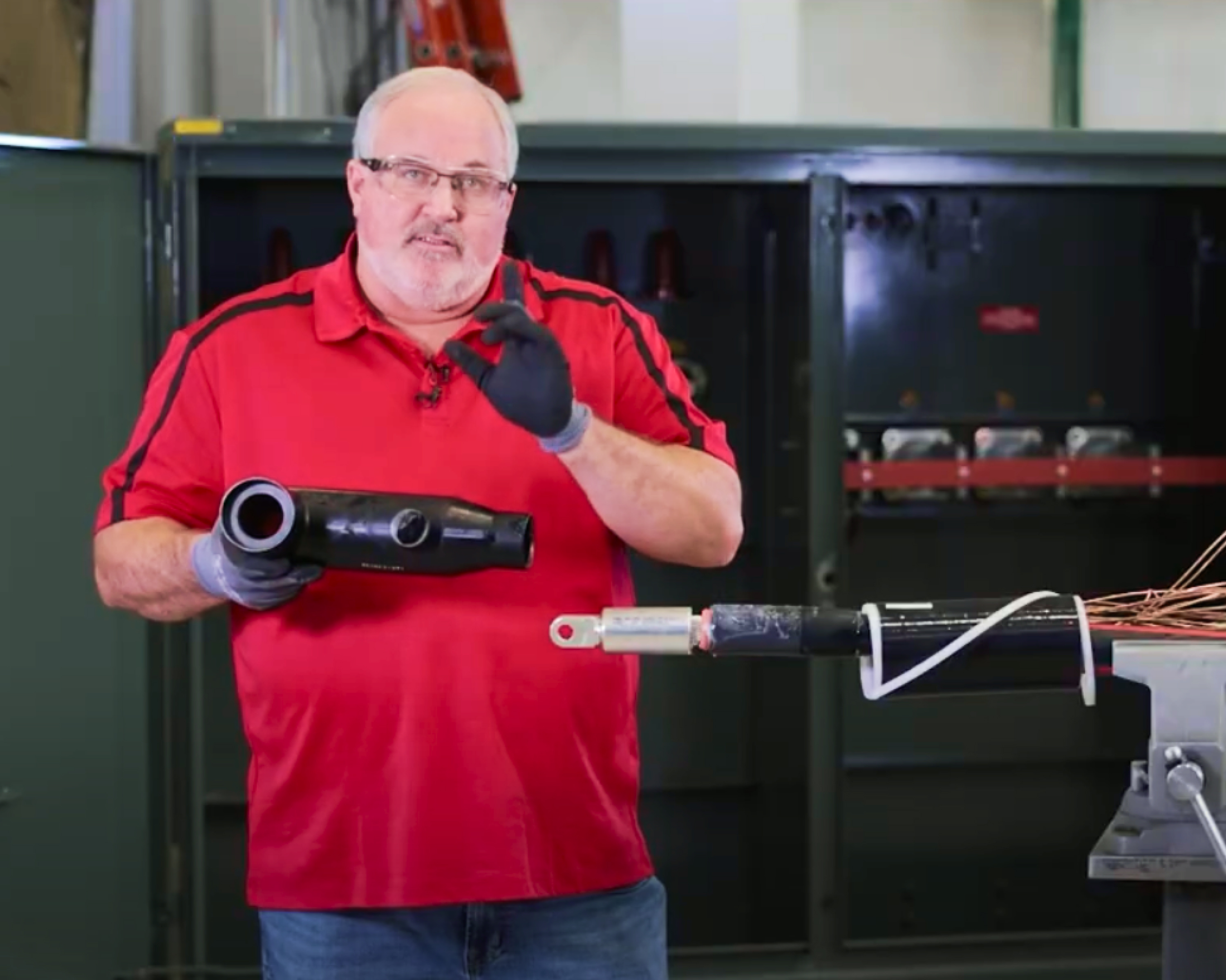 Technician holding a 600 amp T-Body head next to a prepared cable 
