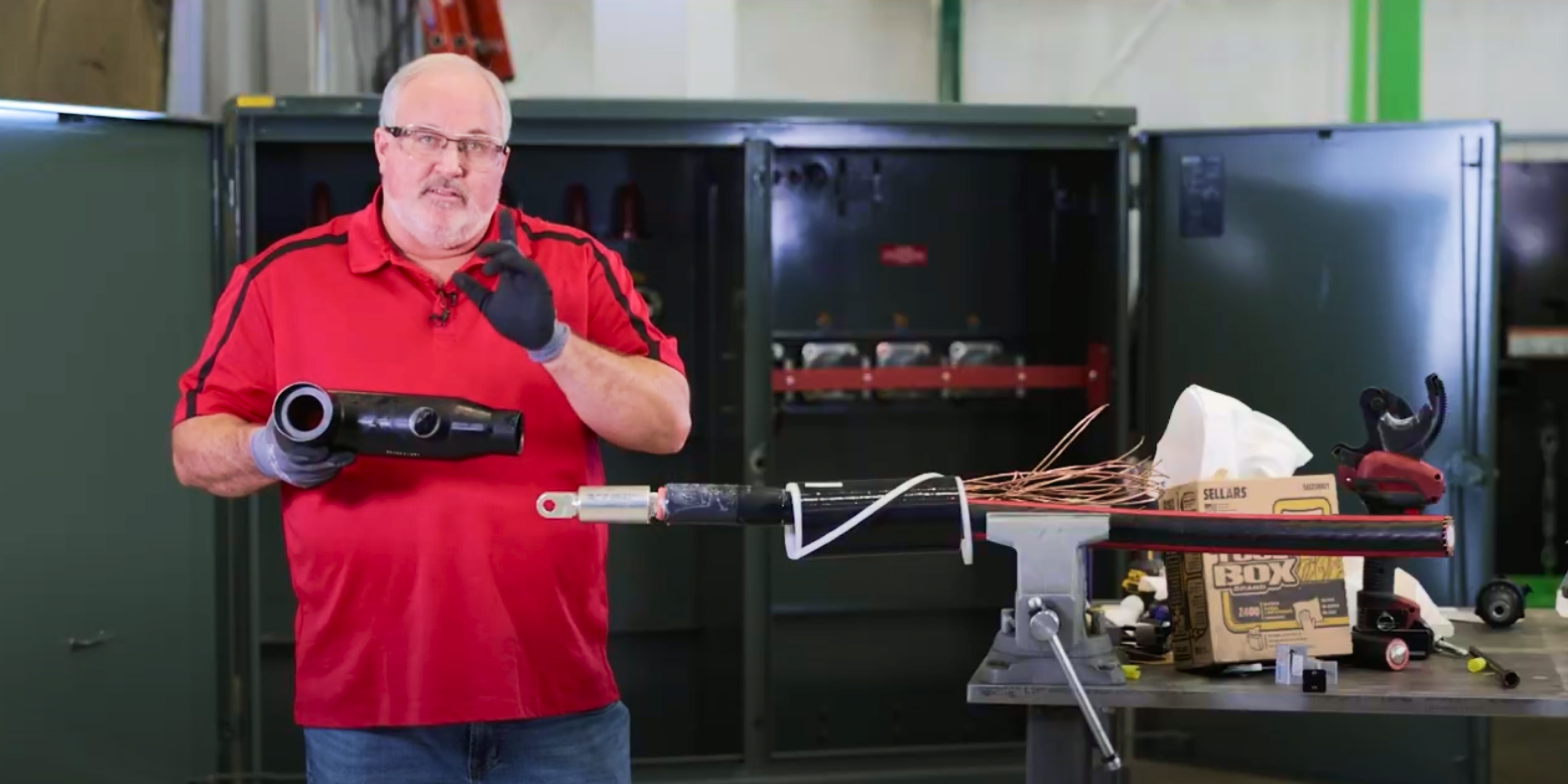 Technician holding a 600 amp T-Body head next to a prepared cable 