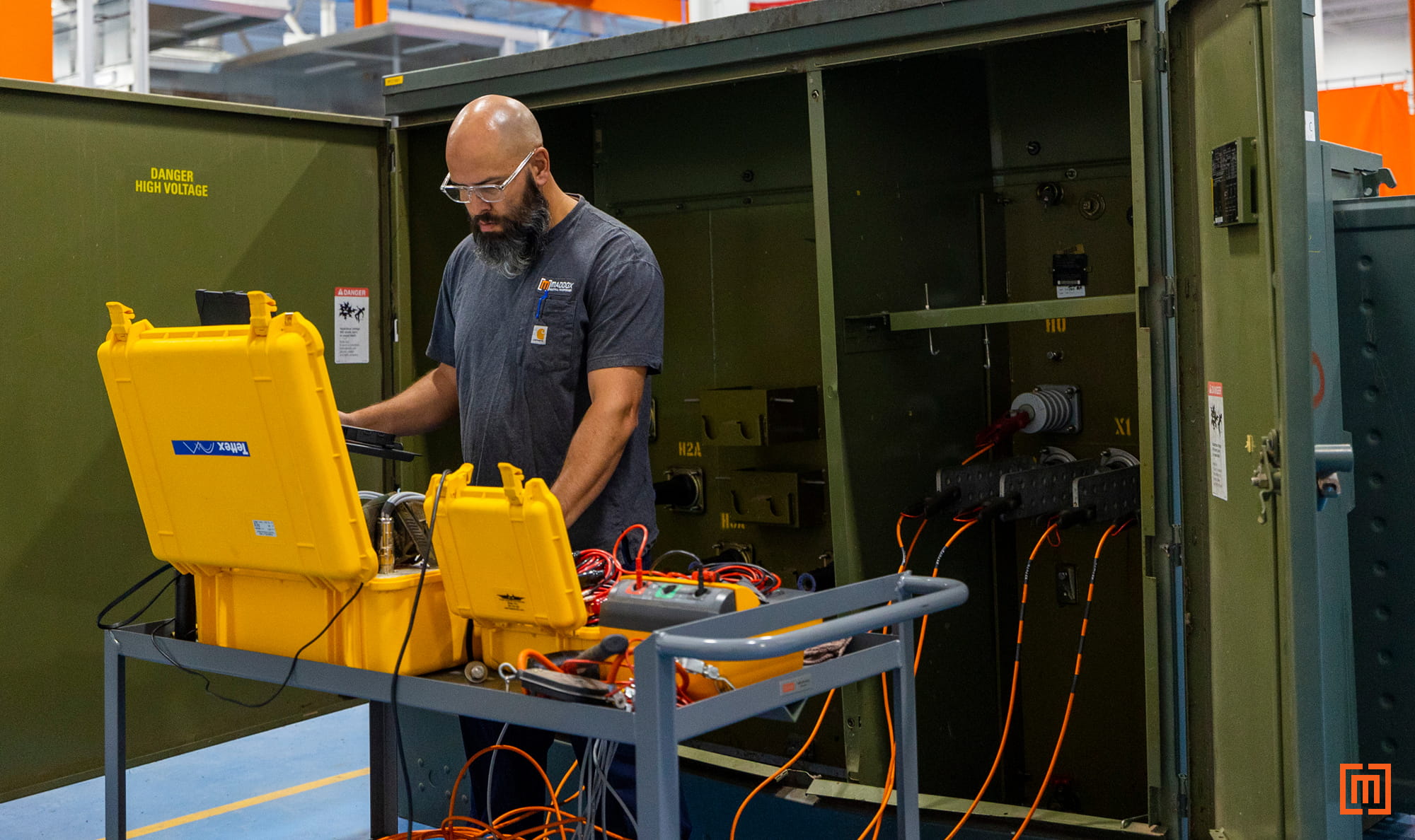Maddox transformer tech performing testing on open green padmount