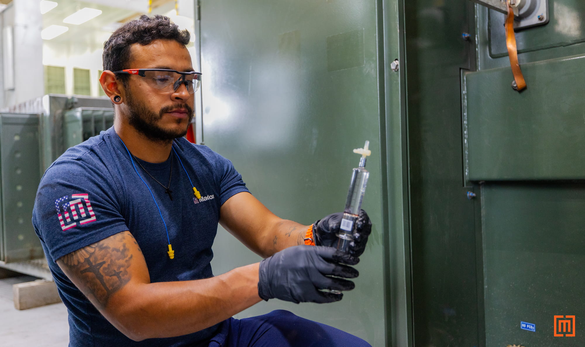 photo of Maddox tech holding padmount DGA sample in warehouse