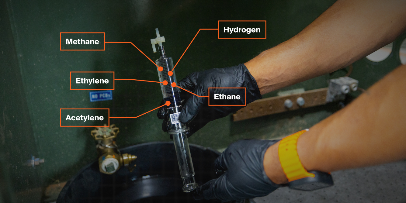 A transformer technician holding up a padmount oil sample before it is DGA tested.
