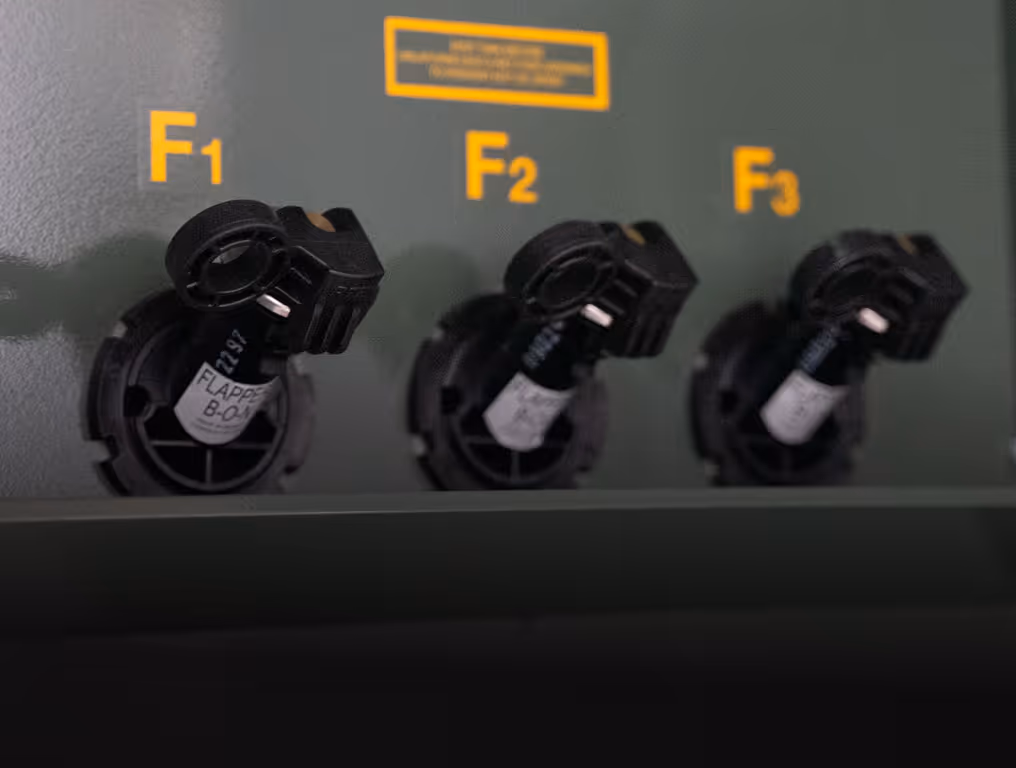 Three black plastic knobs labeled F1, F2, and F3 on a green panel with yellow lettering.