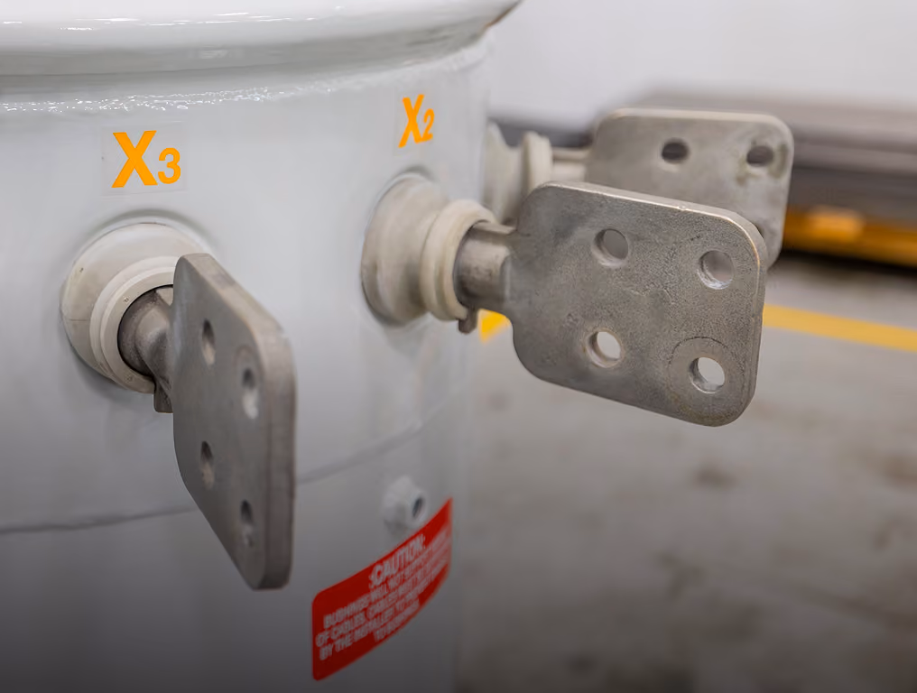 Close-up of liquid temperature gauge on gray industrial equipment with a blue sky background.