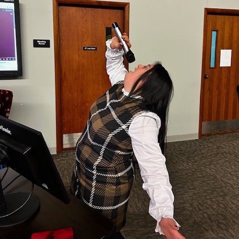 A young woman belts out a song singing karaoke.