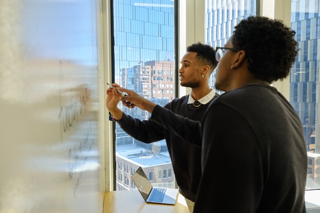 Two software engineers coding on whiteboard
