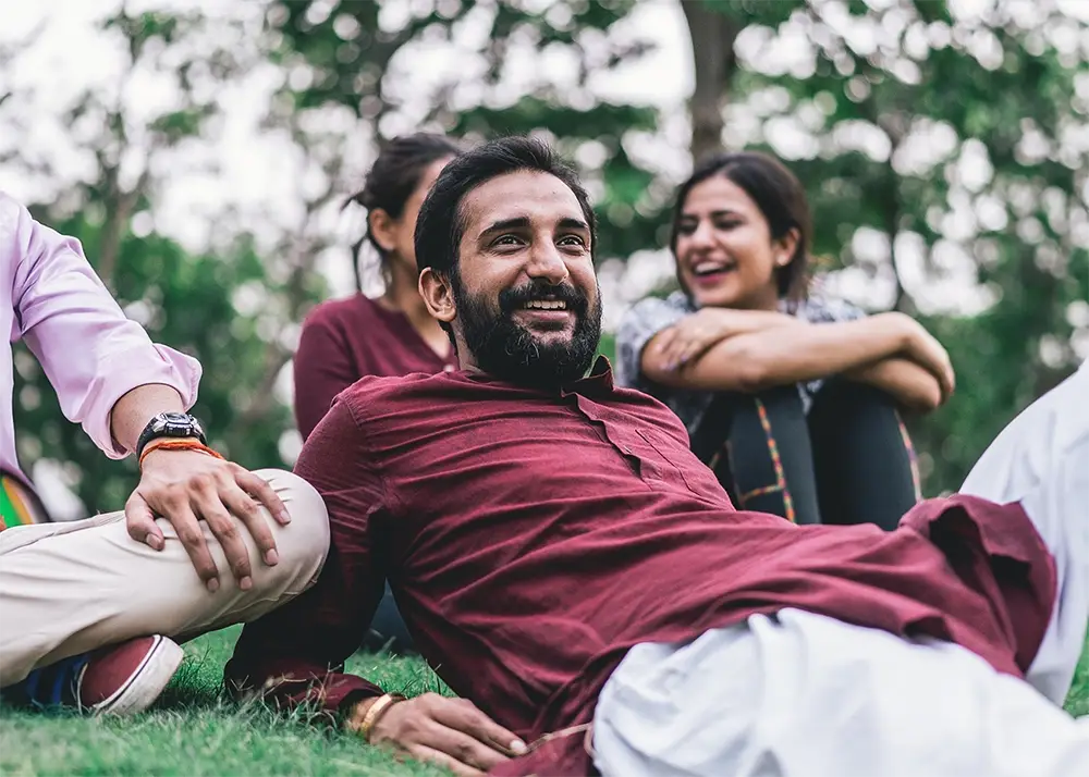 Man smiling, lounging in the park