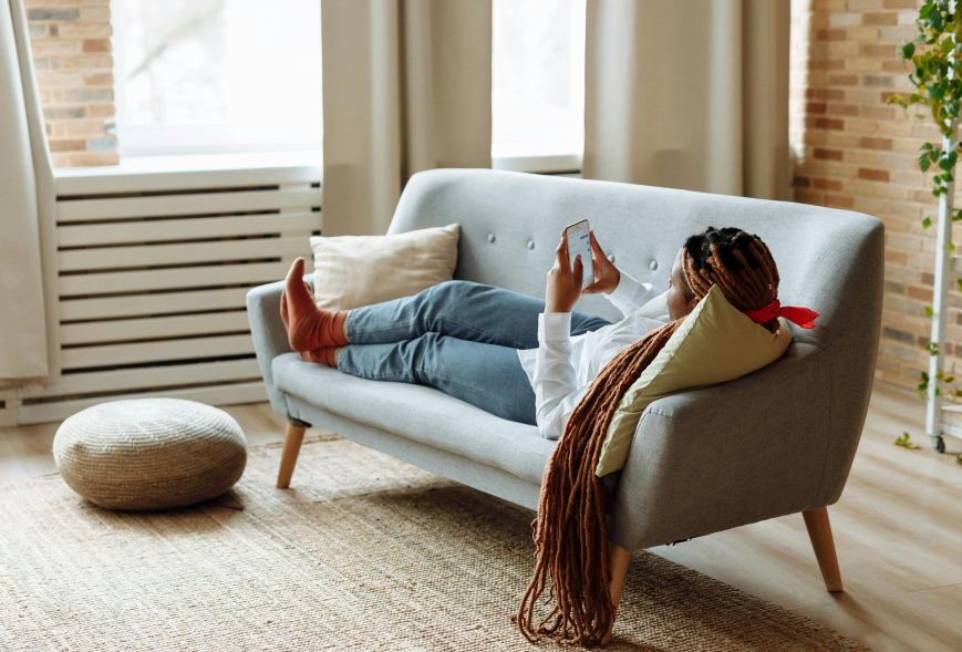 Girl on couch in apartment, looking at her phone