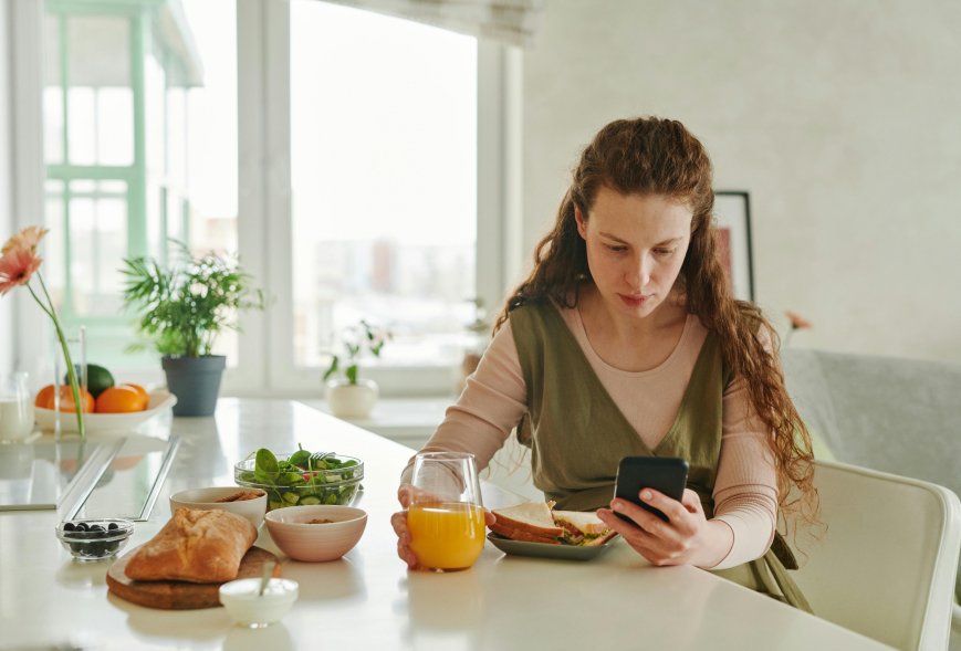 Woman looking at her phone at her apartment counter