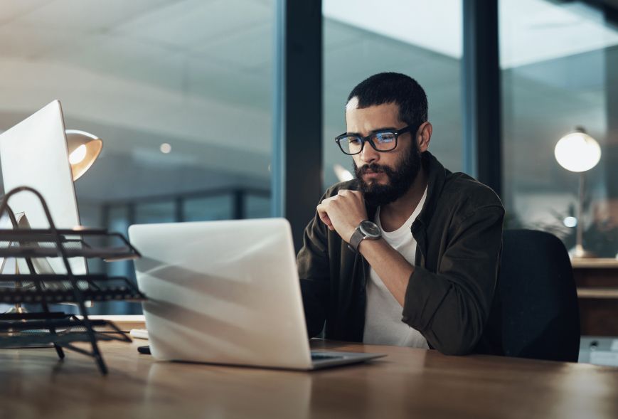 Man looking at his laptop with a straight face