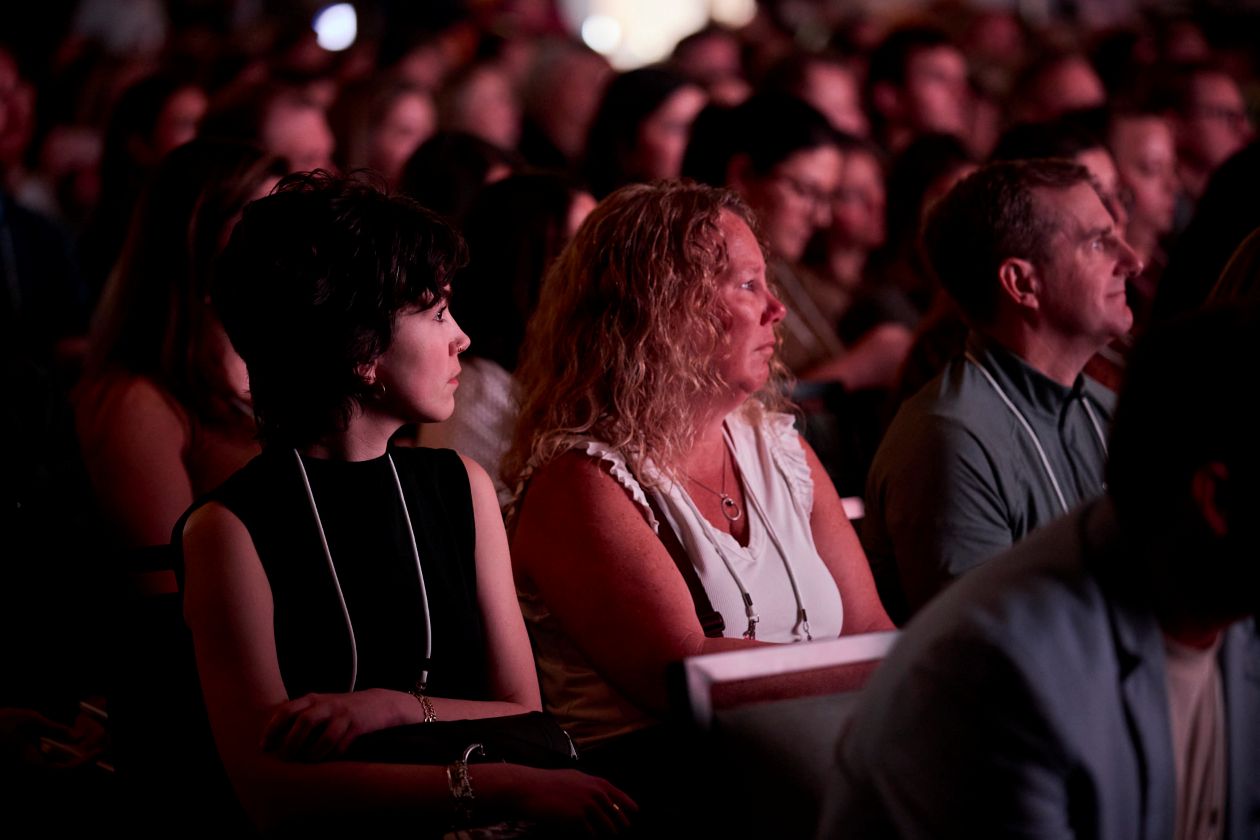 People in an audience with purple lighting