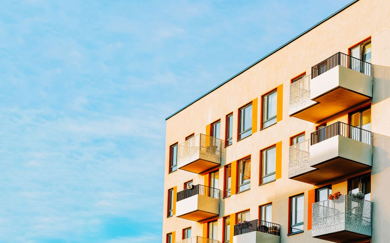 A yellow apartment in front of a blue sky