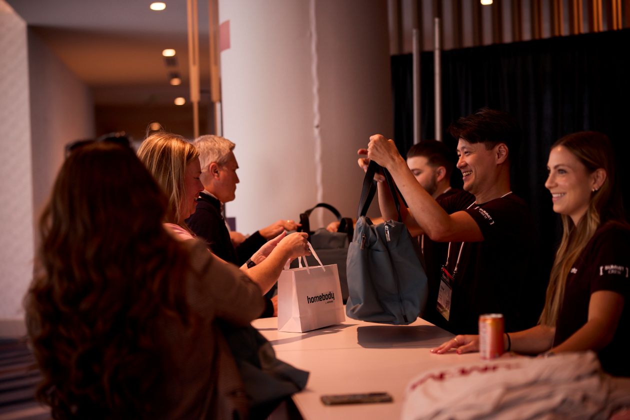 People giving out Summit swag across a counter