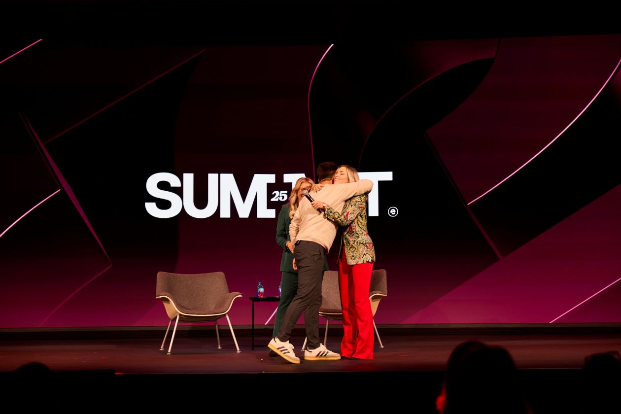 Three people hugging on the Summit stage