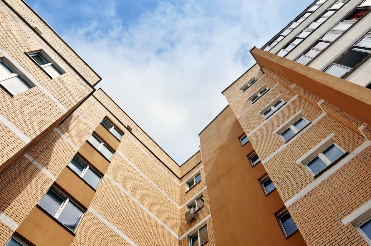 A [icture taking looking up at a yellow apartment building