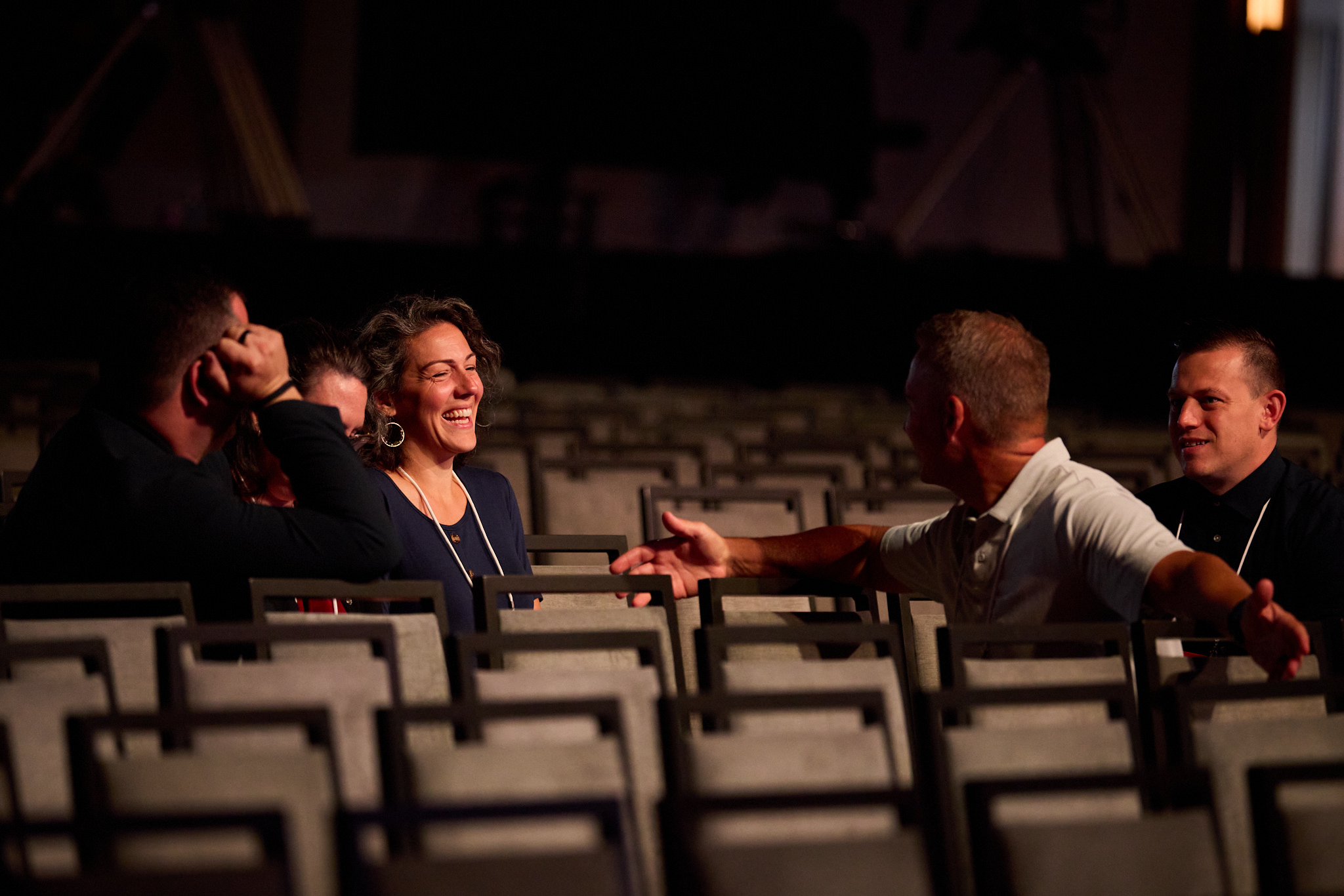 A woman in the stage seats smiling at someone else